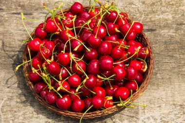 Antika ahşap masa üzerinde kırmızı tatlı kiraz meyve sepeti. Yaz meyve sezon kavramı