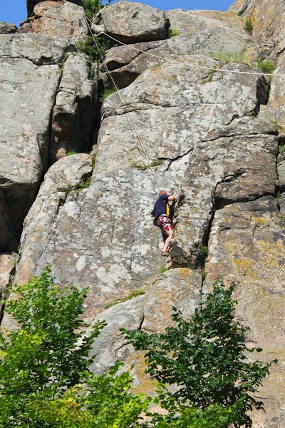 Hombre escalador trepando en una roca — Foto de Stock