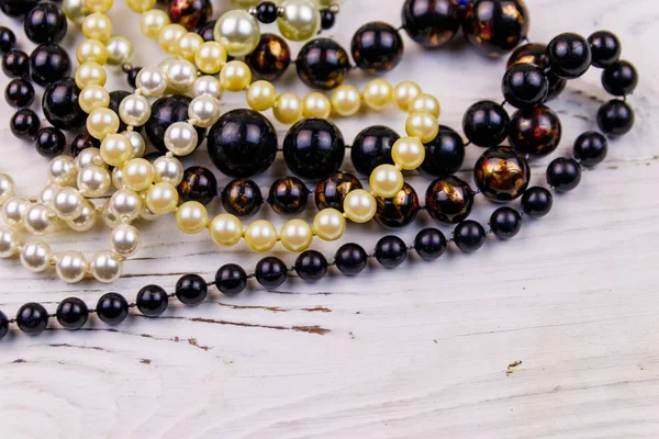 Olika pärlor halsband på vit trä bakgrund — Stockfoto