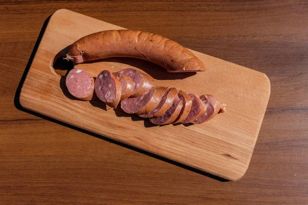 Räucherwurst auf einem Holzbrett auf einem Tisch — Stockfoto