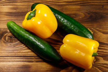 Ahşap masada taze salatalık ve sarı biber