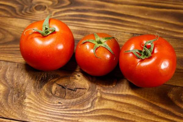Świeże dojrzałe pomidory na drewnianym stole — Zdjęcie stockowe