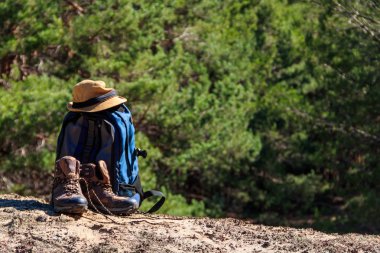 Turist sırt çantası, yürüyüş botları ve çam ormanında şapka. Yürüyüş konsepti