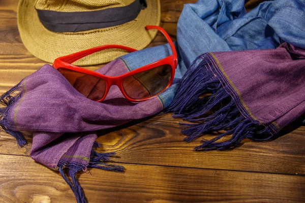 Rote Sonnenbrille, Strohhut und Sommerschal auf Holzgrund — Stockfoto