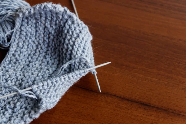 Processus de tricot. Tricoter la laine et les aiguilles à tricoter sur une table en bois — Photo