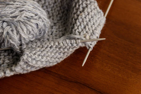Processus de tricot. Tricoter la laine et les aiguilles à tricoter sur une table en bois — Photo