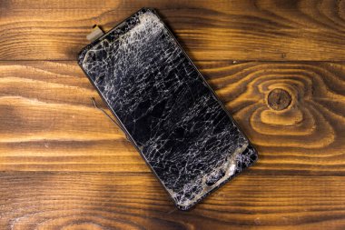 ahşap arka plan üzerinde kırık ekran ile Smartphone