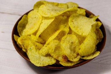 Beyaz ahşap masada patates cipsi tabağı