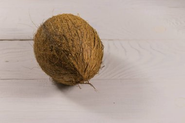 Beyaz ahşap masadaki hindistan cevizi.