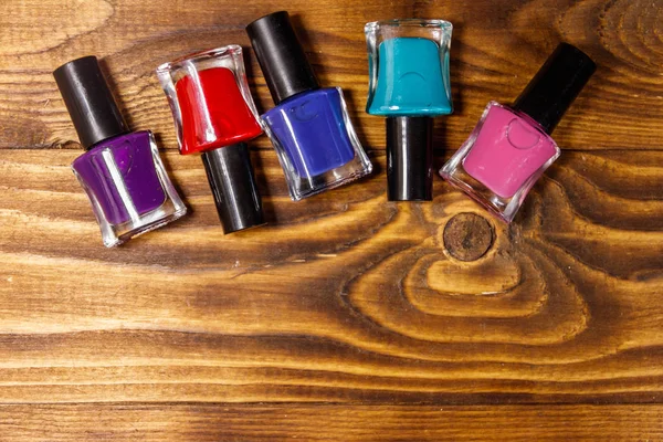 Set of nail polish bottles on wooden background