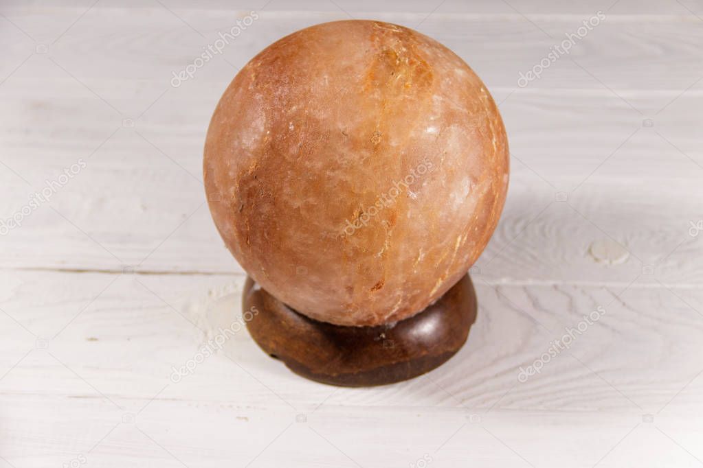 Himalayan salt lamp on white wooden background