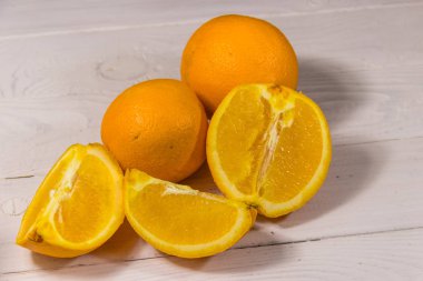 Beyaz ahşap masada taze portakallar.