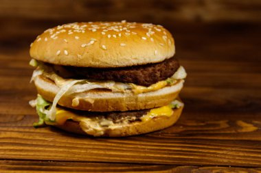 Ahşap masada lezzetli büyük hamburger.