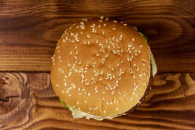Ahşap masada lezzetli büyük hamburger.