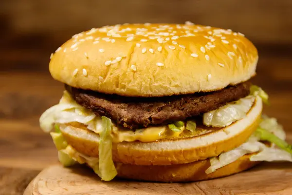 Смачний великий гамбургер на дерев'яному столі — стокове фото