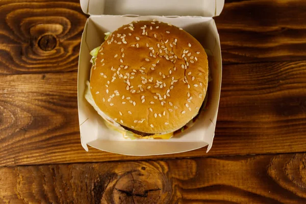 나무 테이블에 골 판지 상자에 맛 있는 큰 햄버거 — 스톡 사진