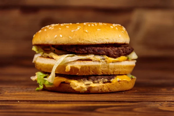 Leckerer großer Hamburger auf Holztisch — Stockfoto