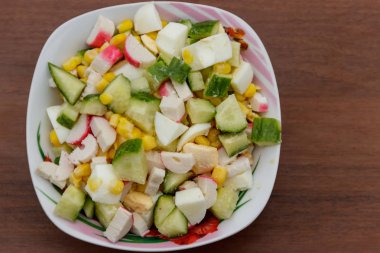 Yengeç sopa, tatlı mısır, salatalık ve ahşap masa üzerinde yumurta salatası. Üstten Görünüm