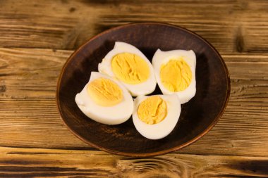 Ahşap masa üzerinde bir tabakta haşlanmış yumurta