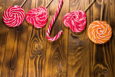 Kırsal ahşap arka planda tatlı lolipoplar. Üst görünüm