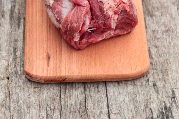 Carne de porco crua em tábua de corte em uma mesa — Fotografia de Stock