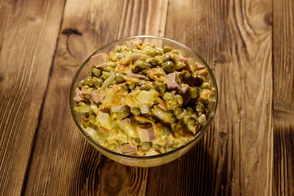 Majonez sałatkowy z kiełbasa, groszek zielony, marchew i cebulę na drewnianym stole — Zdjęcie stockowe