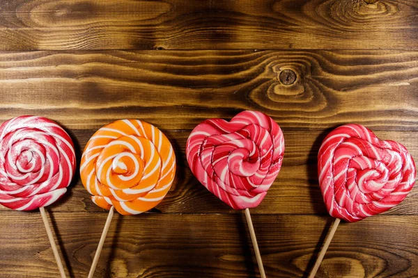 Sweet lollipops on rustic wooden background. Top view — Stock Photo, Image