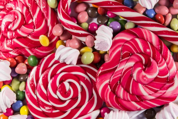 Фон з різнокольорових шоколадних цукерок, льодяників, цукерок тростини і зефіру — стокове фото