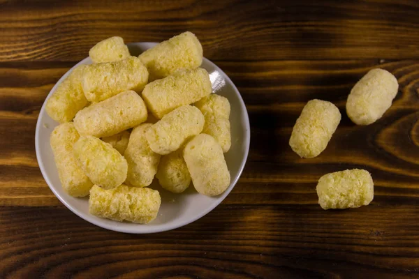 Sweet corn sticks on a plate on wooden table