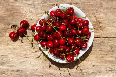 Rustik ahşap masa üzerinde taze olgun kiraz ile top. Üstten görünüm