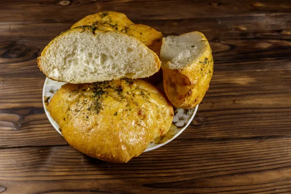 Pan fresco ciabatta en un plato sobre mesa de madera — Foto de Stock