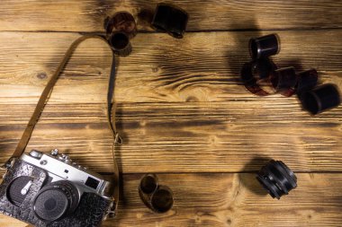 Ahşap masanın üzerinde fotoğraf makinesi ve lens olan eski fotoğraf makinesi.