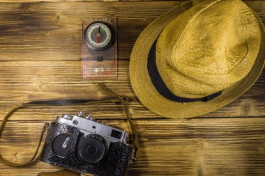Ahşap arka plan üzerinde Pusula, şapka ve retro fotoğraf makinesi