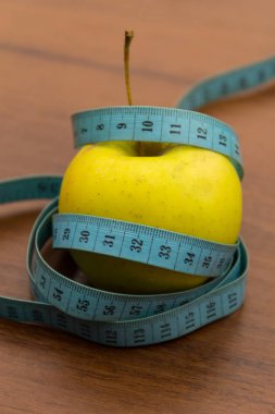 Tahta masada şerit ve yeşil elma ölçüyorum. Diyet ve sağlıklı yaşam tarzı kavramı