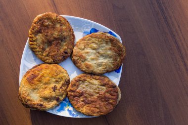 Ahşap masa üzerinde bir tabak içinde kızarmış pirzola. Üstten Görünüm