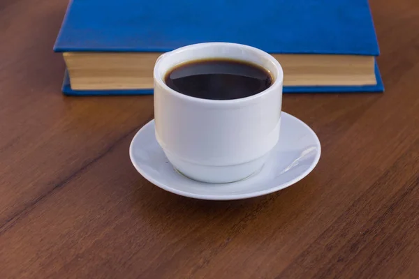 Tazza di caffè e libro sul tavolo di legno — Foto Stock