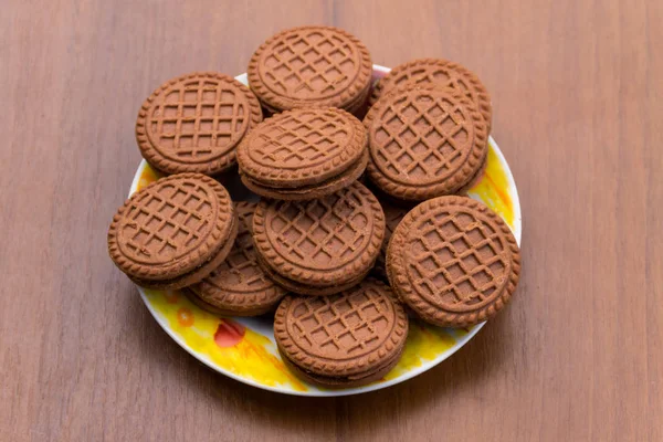 Biscuits au chocolat avec garniture crème sur table en bois — Photo