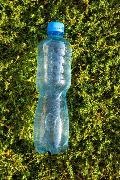 Garrafa com água limpa fresca na grama verde — Fotografia de Stock