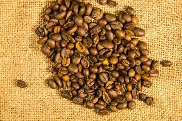 Roasted coffee beans on sackcloth woven background — Stock Photo, Image