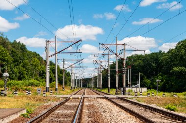 Kırsal alanda doğal demiryolu ve yaz aylarında beyaz bulutlar ile mavi gökyüzü