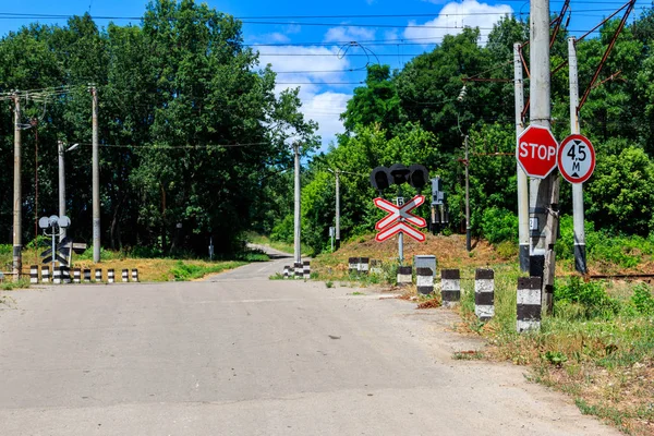 Залізниця перетинає заміську дорогу в лісі — стокове фото