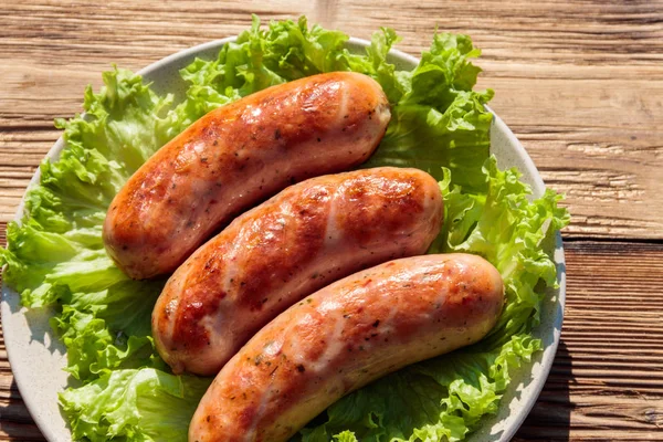 Grilled sausages on wooden table — Stock Photo, Image