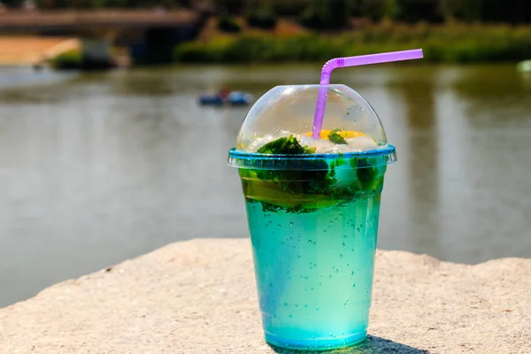 Mojito-Cocktail mit Zitrone, Eis und Minzblättern auf Flusshintergrund — Stockfoto