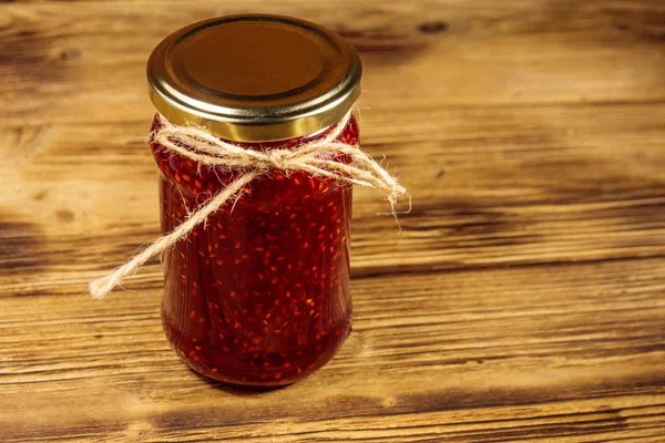 Himbeermarmelade im Glas auf Holztisch — Stockfoto