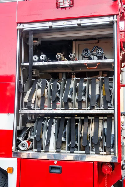 Equipo de rescate de camiones de bomberos. Compartimento de las mangueras de incendio enrolladas en un camión de bomberos — Foto de Stock