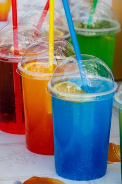 Kokteyl pipetleri ile plastik bardak renkli soğuk tonlama kokteyller