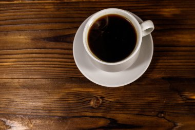 Tahta masada bir fincan kahve. Üst görünüm