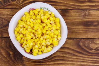 Ahşap masa üzerinde bir kase konserve mısır