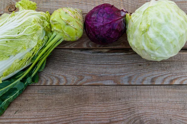 Several kinds of cabbage on rustic wooden table. Top view, copy space — Stock Photo, Image