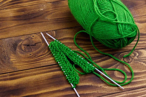 木製のテーブルの上に編み物と糸と編み針のボール — ストック写真